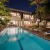 Downtown Villas in Kuta with lit outdoor pool, lounge chairs, and poolside cabana at night