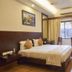 Rkn Hotel Pondicherry guest room with double bed, desk, window curtains and wall-mounted AC