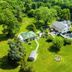 Stone Manor Boutique Inn in Lovettsville, aerial view of the inn, lawn, trees and patio