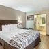 Red Roof Inn Danville, PA guest room with king bed, desk, mini fridge and open bathroom door