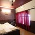Hotel Ajay International Agra guest room with twin bed and red curtains