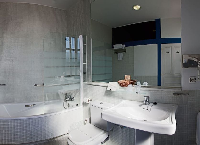 Las Carolinas Garden Santander bathroom with bathtub, sink, mirror and blue trim
