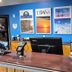 Bay Inn in Tawas City front desk with blue wall art, computer monitors, and lighthouse decor