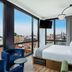 Moxy NYC Lower East Side room with floor-to-ceiling windows and Manhattan skyline views in New York