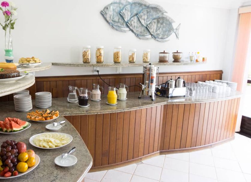 Gentil Hotel Florianopolis breakfast buffet with fruit, pastries, drinks and dining counter
