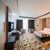Grand Paragon Hotel Johor Bahru guest room with bed, chairs, desk and patterned carpet in Johor Bahru
