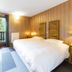 Hotel La Fontaine in Les Houches bedroom with double bed, balcony doors, and forest view