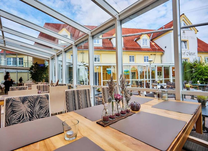 Flair Hotel Zum Schwarzen Reiter in Horgau, glass-roofed restaurant terrace with outdoor seating