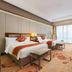 The Longemont Shenyang guest room with two beds, floor-to-ceiling window, and seating area