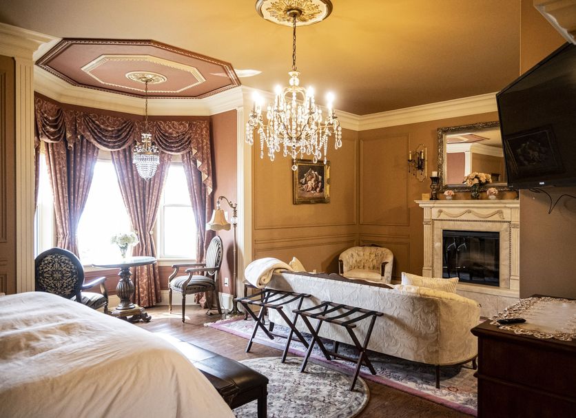 Belle View Manor Inn Harbour Grace guest room with chandelier, fireplace, sitting area and TV