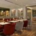 The Cura Hotel Kensington, London bar and restaurant with red banquettes and gray dining chairs
