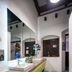 Adra Hostel in Antigua bathroom with double sink vanity, large mirror, and teal geometric tile floor