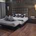 The Platinum Hotel in Hyderabad guest room with king bed, tufted headboard, lounge chair and wood floors