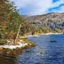 Hostal de la Laguna in Ushuaia with a mountain lake, snowy shoreline, and waterfall