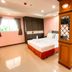 Aa Pattaya Ville room in Pattaya with bed, window, seating area and decorative wood partition