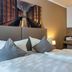 Auto-Parkhotel Hamburg St Pauli room with twin beds, city wall art, and a sink area in Hamburg