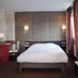 Europe Hotel in Haguenau guest room with double bed, desk, chair, and striped curtains