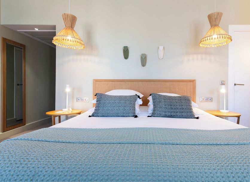 Hôtel Cézanne Boutique Hôtel in Aix-en-Provence bedroom with king bed, blue bedding and woven pendant lights
