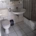 Hotel Am Markt in Eckartsberga bathroom with toilet, sink, mirror, shower and tiled walls