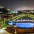 Acoya Curacao Resort, Villas & Spa in Willemstad with lit pool, landscaped gardens and evening skyline view