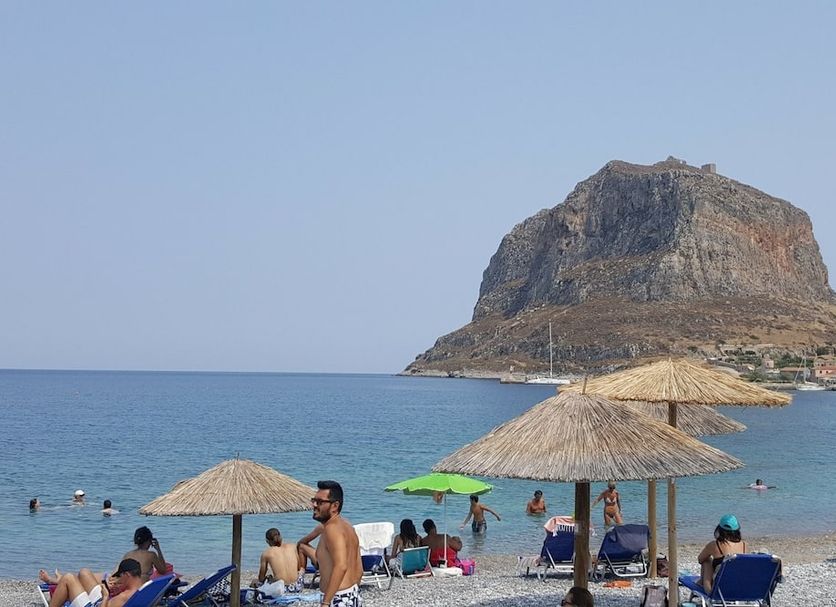 The Flower Of Monemvasia Hotel in Monemvasia with beach umbrellas and sea views of the rocky islet