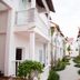 Volga Apartment Hotel in Mũi Né with white balconies and a landscaped walkway between buildings
