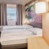 B&B Hotel Wiesbaden-Ost room with twin beds, wall-mounted TV and window view in Wiesbaden
