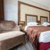 Kaisheng Xingfeng International Air in Beijing: twin beds, upholstered chair and glass partition in a guest room