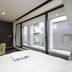 Oakhostel Zen Tokyo room with bed, desk, chair and large balcony doors