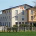 Hotel Ackermann in Riedstadt, three-story hotel exterior with a fenced lawn and trees