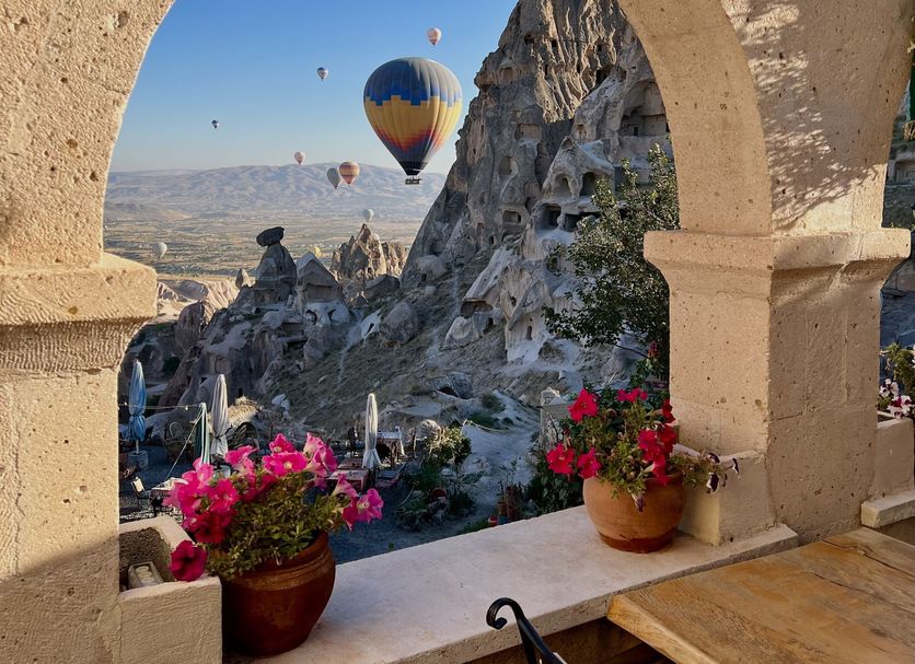 Duven Hotel Cappadocia in Uchisar with hot air balloons over Cappadocia rock formations and flowers