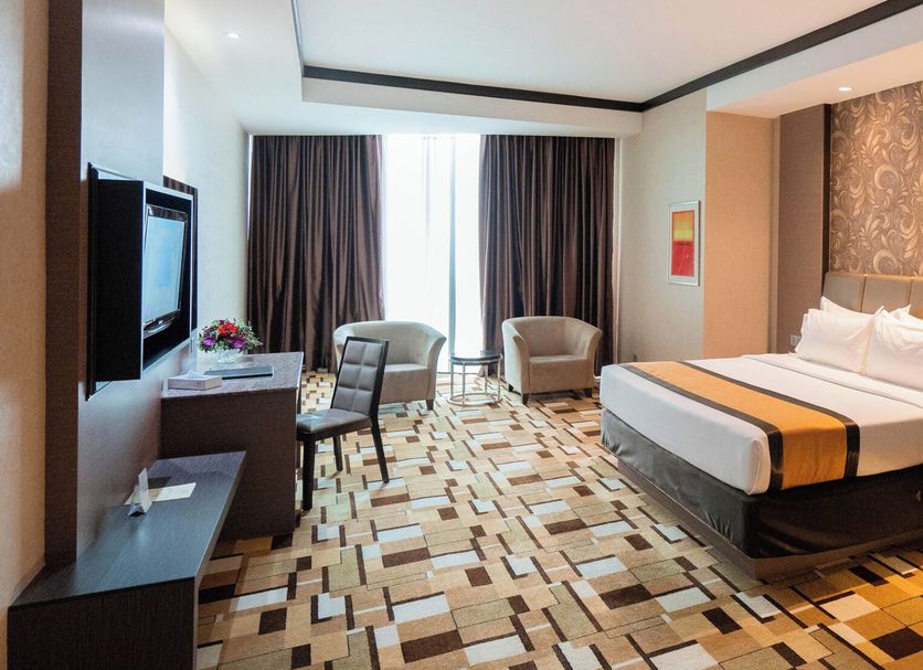 Grand Paragon Hotel Johor Bahru room with king bed, seating area, and patterned carpet in Johor Bahru