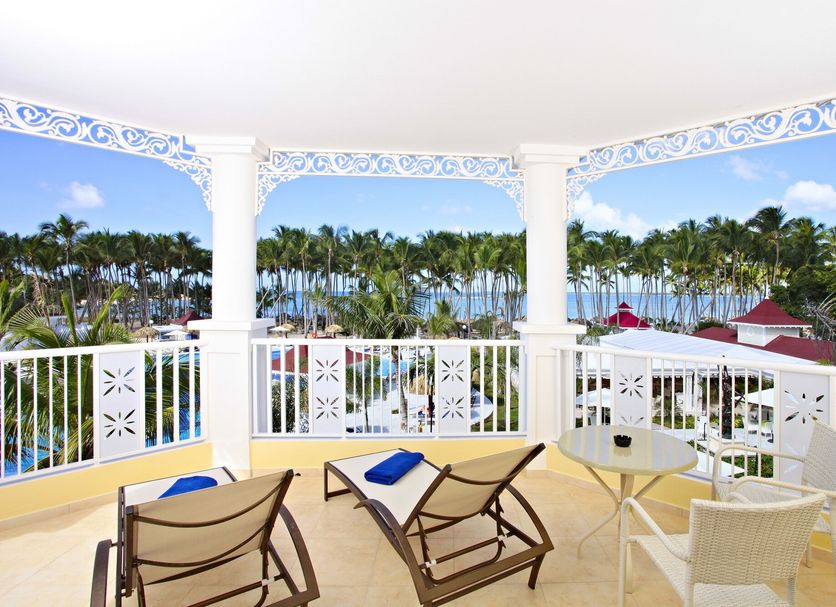 Bahia Principe Luxury Bouganville in La Romana balcony with lounge chairs and tropical resort and ocean view