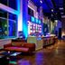 Aloft Seattle Redmond lobby lounge with bar seating, red sofas, and colorful modern lighting