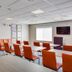 Quality Inn & Suites Bethany - Oklahoma City West meeting room with tables, orange chairs and wall art
