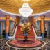 Hulunbeier Hotel in Hulunbuir lobby with grand chandelier, red staircase and floral centerpiece