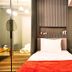 Taks-Inn Suites Istanbul guest room with twin beds, modern wall paneling and bedside table