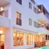 Erato Hotel in Agia Marina with lit balconies and a small pool courtyard at dusk