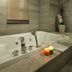 Hotel Pharos Seoul bathroom with corner soaking tub, candles, window blind and tiled walls