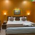 Hotel Sagar Kanya Inn Puri room with double bed, bedside lamps and seating area