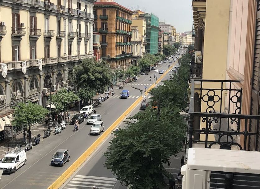Napoli Svelata in Naples with a balcony view over a busy city street and historic buildings