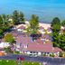 The Beach House in Mackinaw City overlooking a lakeside resort area with trees and cottages