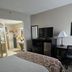 Baymont by Wyndham Janesville room with bed, TV, desk and bathroom vanity