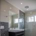 Sea Breeze Guesthouse in Swakopmund bathroom with glass shower, wall-mounted sink, toilet, and mosaic tile accents