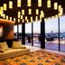 Memmo Principe Real, Lisbon: chic lounge with hanging lights and city-view terrace through glass doors