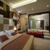 Thotel Lamezia in Feroleto Antico: modern guest room with bed, mirrored wall and raised lounge seating