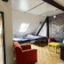 Homeplanet Hostel Leipzig loft room with twin beds, skylight, brick wall, and lounge seating