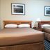 Medicine Hat Suites in Medicine Hat guest room with two double beds and bedside lamp