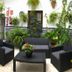 Hostal Mellizo in Lebrija courtyard with black lounge chairs, table and lush potted plants