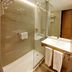 Brizo Salta bathroom with glass shower, wall-mounted sink, towel rack and wood door in Salta